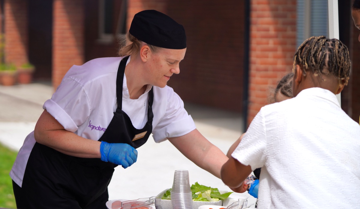 Signature team member serving food outside